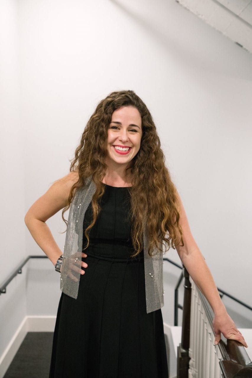 Kristen Millares Young smiles at camera wearing a black dress