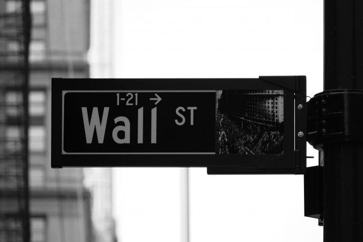 A black and white close-up of a sign that says "Wall St."